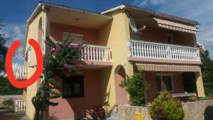 a house with a red circle in front of it at Apartmani Stojan in Povljana