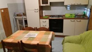 a small kitchen with a table and a stove at Apartmani Stojan in Povljana