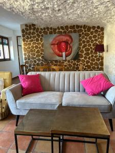 soggiorno con divano e cuscini rosa di Cueva de la Abuela María ad Alcalá del Júcar