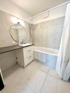 ein Badezimmer mit einem Waschbecken, einem Spiegel und einer Badewanne in der Unterkunft FORSTHAUS 28 FREE GARAGE in Wien