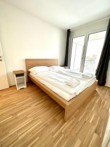ein Schlafzimmer mit einem großen Bett und Holzboden in der Unterkunft FORSTHAUS 28 FREE GARAGE in Wien