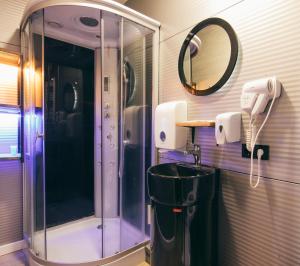 a bathroom with a shower and a sink and a mirror at Landscapes Hotel Kazbegi in Stepantsminda