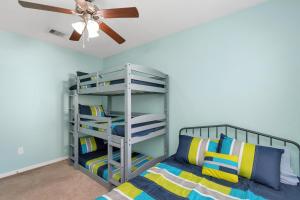 a bedroom with a bunk bed and a ceiling fan at Summer Bliss,Blocks to the Beach-Midtown Galveston in Galveston