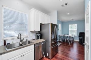 a kitchen with a sink and a refrigerator at Summer Bliss,Blocks to the Beach-Midtown Galveston in Galveston
