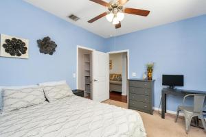 una camera con letto e ventilatore a soffitto di Summer Bliss,Blocks to the Beach-Midtown Galveston a Galveston