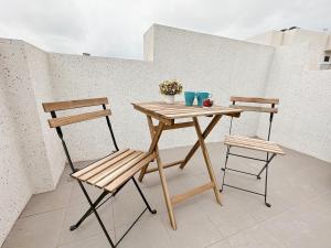 un tavolo di legno e due sedie su un balcone di 芸樂行旅 a Magong