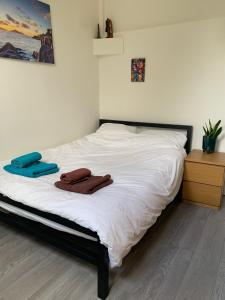 een bed met witte lakens en 2 handdoeken erop bij 1 bed flat near Little Venice and Paddington in Londen