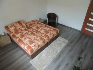 Vila Danmar - rent whole vila or upper floor apartment في Závažná Poruba: غرفة نوم بسرير وكرسي
