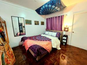 a bedroom with a large bed and a mirror at TAAL VIEW: Townhouse with Pool, Netflix, PS4, Foosball, Karaoke in Tagaytay