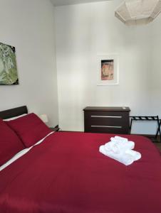 - une chambre avec un lit rouge et des serviettes dans l'établissement Soleluna, à Catane