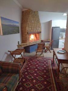 a living room with a fireplace with chairs and a couch at Worcester Garden Cottage in Worcester