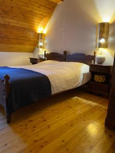 sypialnia z dużym łóżkiem i drewnianym sufitem w obiekcie Luxurious Townhouse Petelin w mieście Plužna