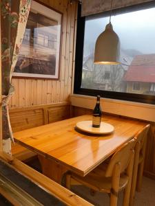 una bottiglia di vino seduta su un tavolo di legno in una stanza di Luxurious Townhouse Petelin a Plužna