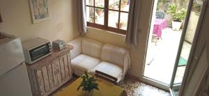 - un salon avec un canapé et une télévision dans l'établissement Terrasse fleurie, à Pézenas