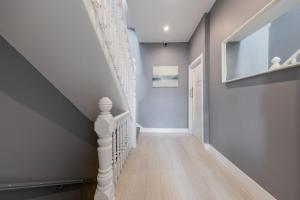 a hallway with a staircase with blue walls and wooden floors at Garden View Standard Double 5Min Walk To Tufnell Park in London