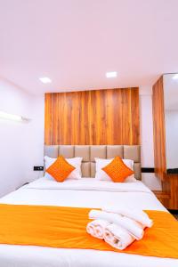 a bedroom with a large bed with orange and white pillows at CALANGUTE CASTLE in Bardez