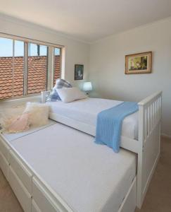 a bedroom with two beds and a window at Tranquil Surf Beach apartment. in Surf Beach