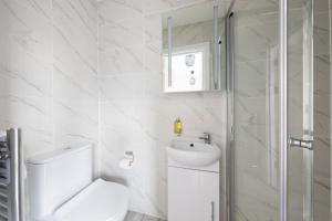 a white bathroom with a toilet and a sink at Garden View Standard Double 5Min Walk To Tufnell Park in London