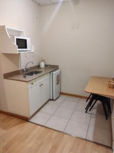 a small kitchen with a sink and a table at Soleado Apart Hotel in San Rafael