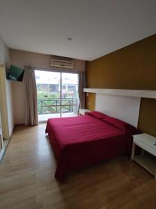 サン・ラファエルにあるSoleado Apart Hotelのベッドルーム1室(赤いベッド1台、大きな窓付)