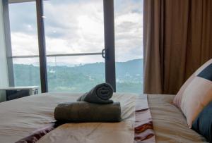 Bett mit einem Stapel Handtücher vor einem Fenster in der Unterkunft KL Exquisite Minimalist Balcony Suite Empire City Marriot in Petaling Jaya