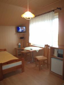 Zimmer mit einem Bett, einem Tisch und einem TV in der Unterkunft Pokoje Magda in Władysławowo