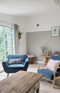 a living room with two blue chairs and a table at Vita Nova in Hippolytushoef