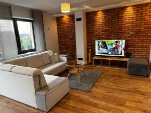 a living room with a couch and a tv at Apartament Airport Gdańsk in Firoga