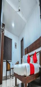 a bedroom with a bed with red pillows at Redbell Suites Manjeri in Manjeri