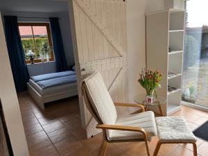 a room with a bed and a chair and a table at Elb Nest Gästehaus in Neu Darchau