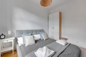 a bedroom with a large bed with blue and white pillows at Skandynawski - 4 osobowy apartament przy Monte Cassino by Grand Apartments in Sopot