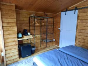 um quarto com uma cama num chalé de madeira em B&B Paardenhof em Wapenveld