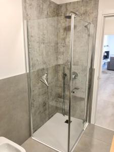 um chuveiro com uma porta de vidro na casa de banho em Panoramic Apartment em Malcesine