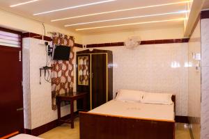 a room with a bed and a tv on a wall at PARI MUTHU VILAS in Chidambaram
