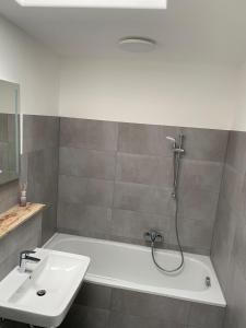 a bathroom with a bath tub and a sink at Ferien- und Businessappartement am Lausitzring in Meuro