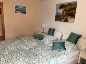 1 dormitorio con 1 cama con almohadas verdes en Ferienwohnung im Grünen mit Balkon en Herdecke