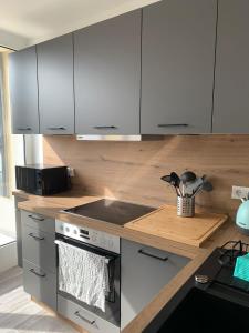 a kitchen with white cabinets and a stove top oven at Ferien- und Businessappartement am Lausitzring in Meuro