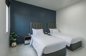 Duas camas num quarto com paredes azuis em Lark Pool Villa Aonang Krabi em Praia de Aonang