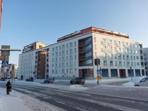 ein großes weißes Gebäude in einer Stadtstraße mit Schnee in der Unterkunft Snow Queen's residence in Rovaniemi