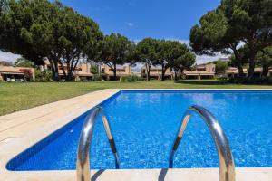 a swimming pool with two metal rails in a yard at Casa de Férias com piscina - Condominio Vilamouraténis in Vilamoura
