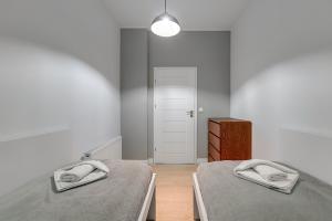 a bedroom with two beds and a dresser in it at Loft Apartment Haffnera Sopot by Grand Apartments in Sopot