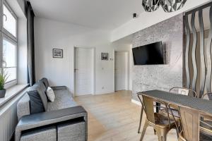 a living room with a couch and a table at Loft Apartment Haffnera Sopot by Grand Apartments in Sopot
