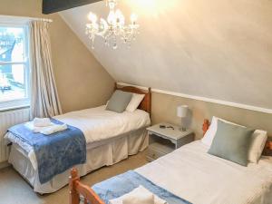 1 Schlafzimmer mit 2 Betten und einem Kronleuchter in der Unterkunft Upton Down in Keswick
