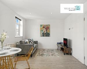 ein Wohnzimmer mit einem Sofa und einem Tisch in der Unterkunft Two Bedroom Apartment by Dream Key Properties Short Lets & Long Lets Uxbridge- 6 in Uxbridge