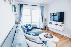 a living room with a blue couch and a table at Ferienwohnung Sunset bei Warnemünde in Rostock