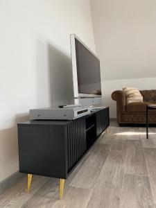a living room with a flat screen tv on a entertainment center at Ferien- und Businessappartement am Lausitzring in Meuro