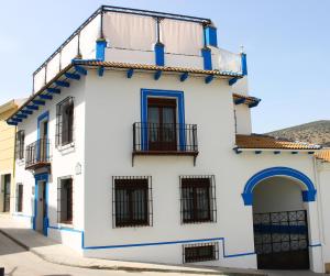 un edificio blanco con adornos azules y balcón en Casa Aurora, en Carcabuey