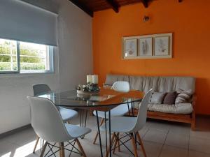a dining room with a table and chairs and a couch at Dúplex La Falda in La Falda