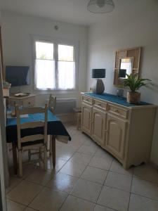 a kitchen with a table and a desk with a plant on it at La villa des fleurs in Lamalou-les-Bains