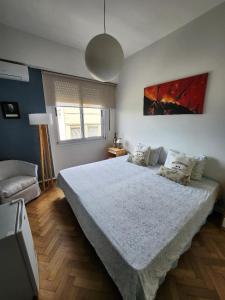 a bedroom with a large bed and a couch at Confortable Habitacion en casa particular con baño compartido in Buenos Aires